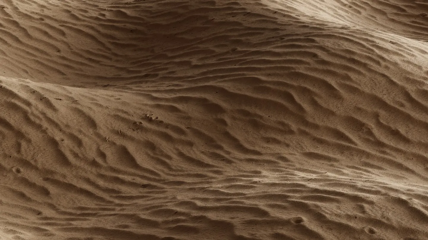 Aerial macro of wind-rippled sand in warm rust tones